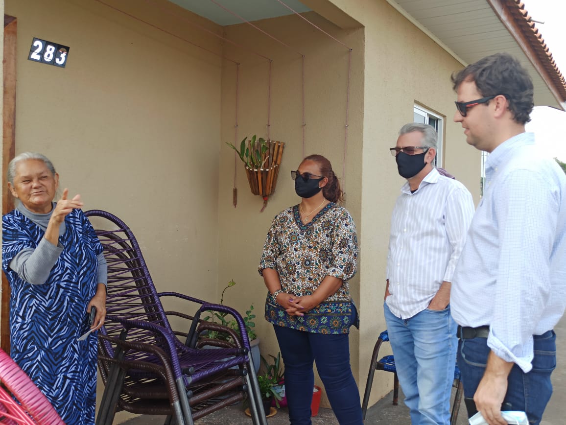 Beth Leal (centro), Professor Santello (2º à dir.) e Vinicius Boza conversam com moradora de casa com energia solar em Santa Tereza