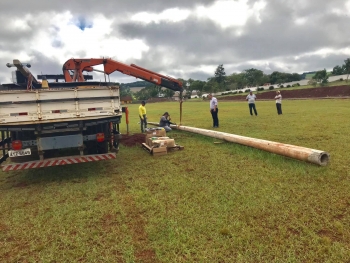 Vereador observa servidores preparando um dos postes instalados na pista de caminhada