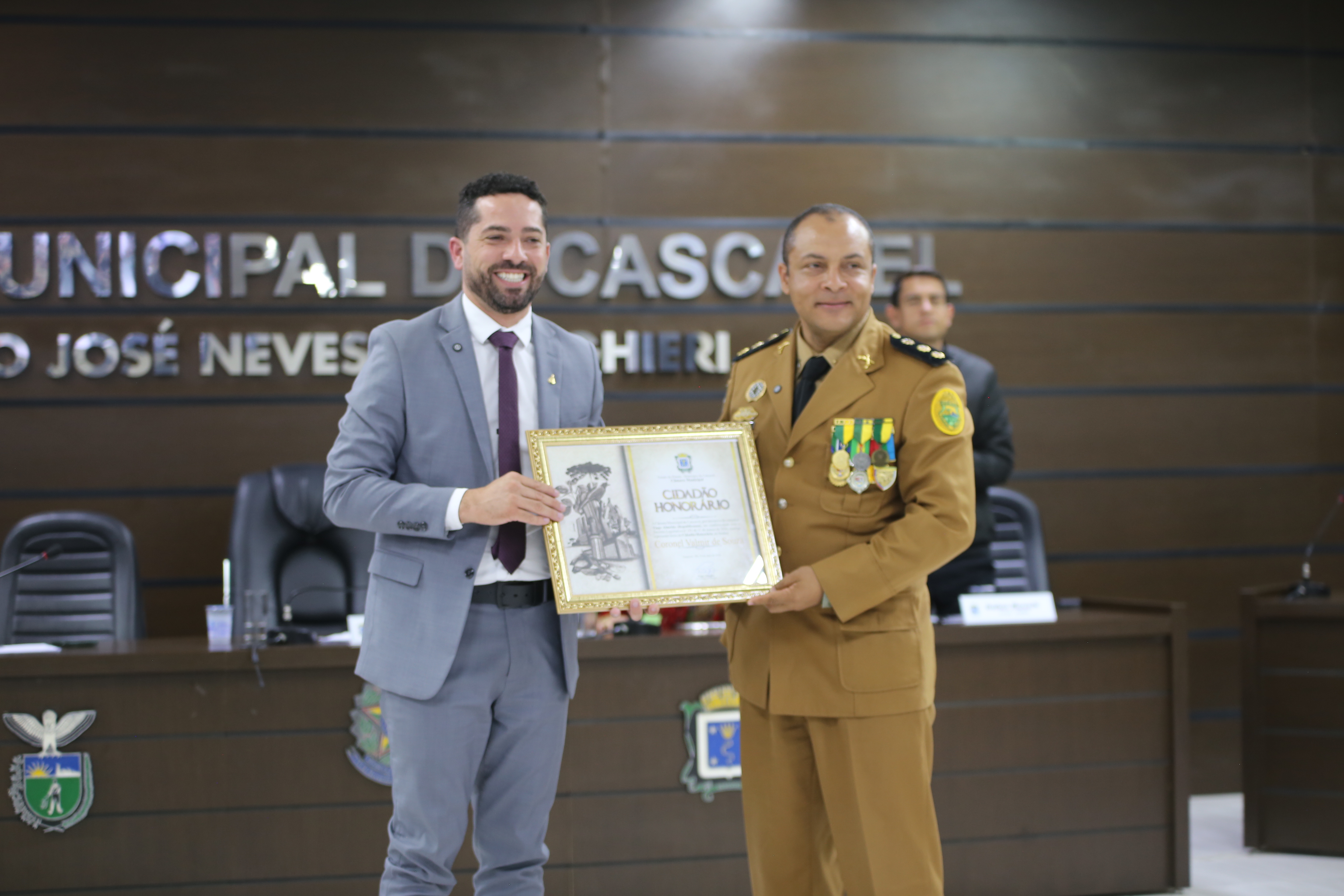 Tiago Almeida, proponente, entrega o quadro ao homenageado coronel Valmir de Souza