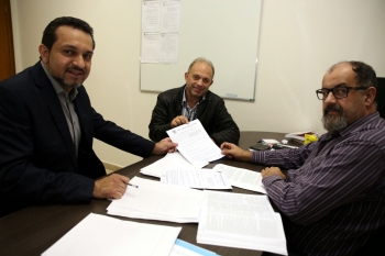 Da esq. para a dir., os vereadores Olavo Santos e Jaime Vasatta apresentam o projeto ao diretor legislativo Mario Galavotti