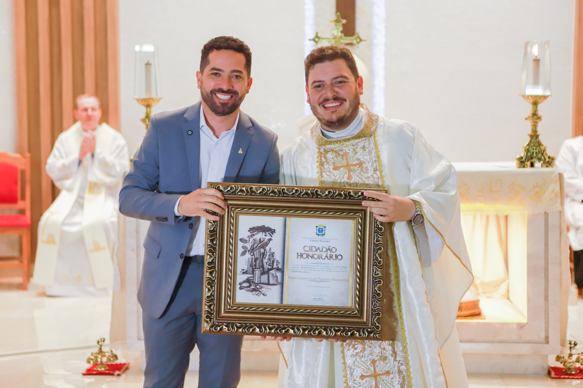 O presidente Tiago Almeida entrega a homenagem ao padre Gustavo Marmentini