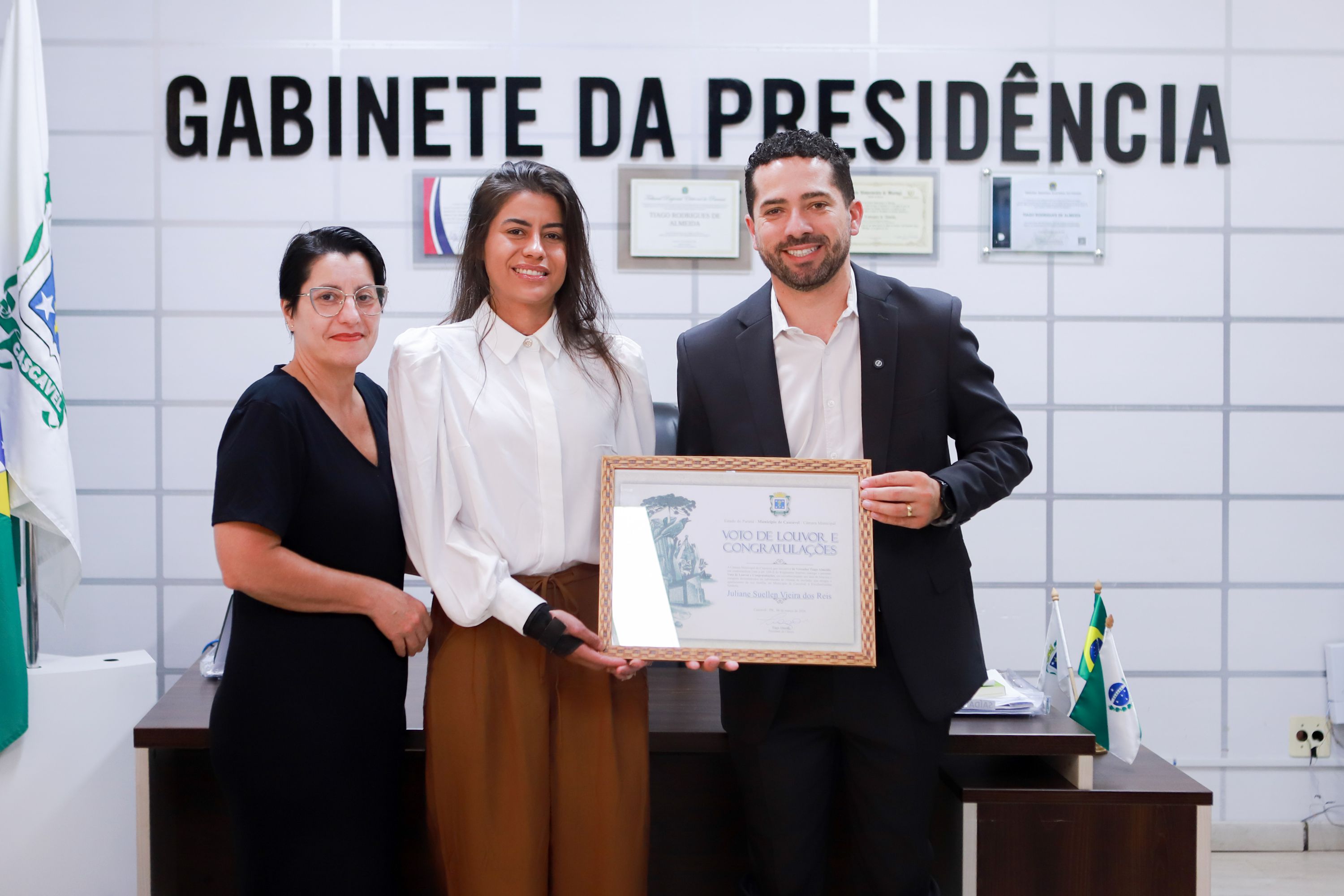 Juliane recebe o quadro com a homenagem do presidente Tiago Almeida, ao lado da mãe Sueli