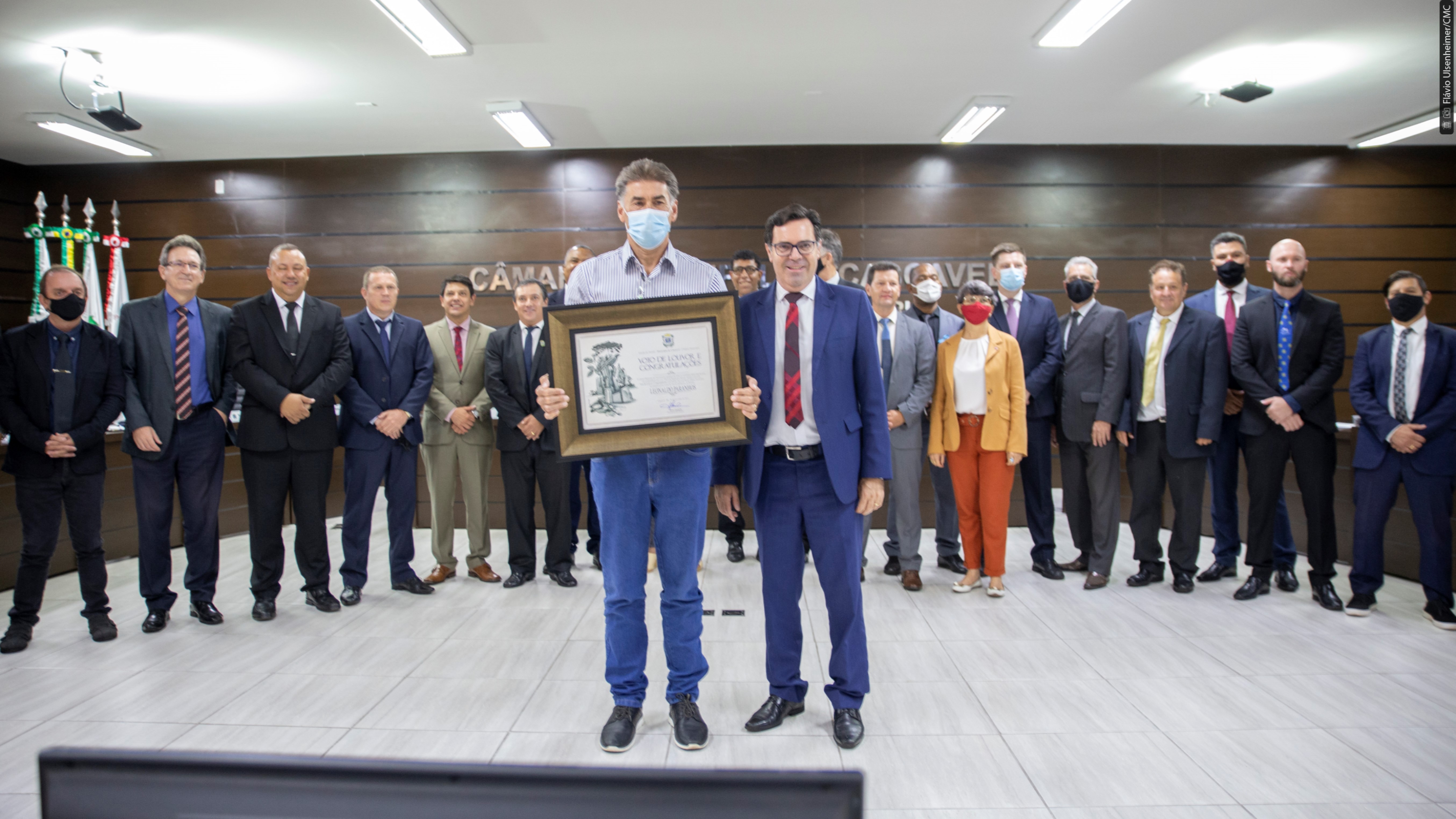 O prefeito Paranhos e o presidente Alécio, com os demais vereadores ao fundo, na entrega da homenagem