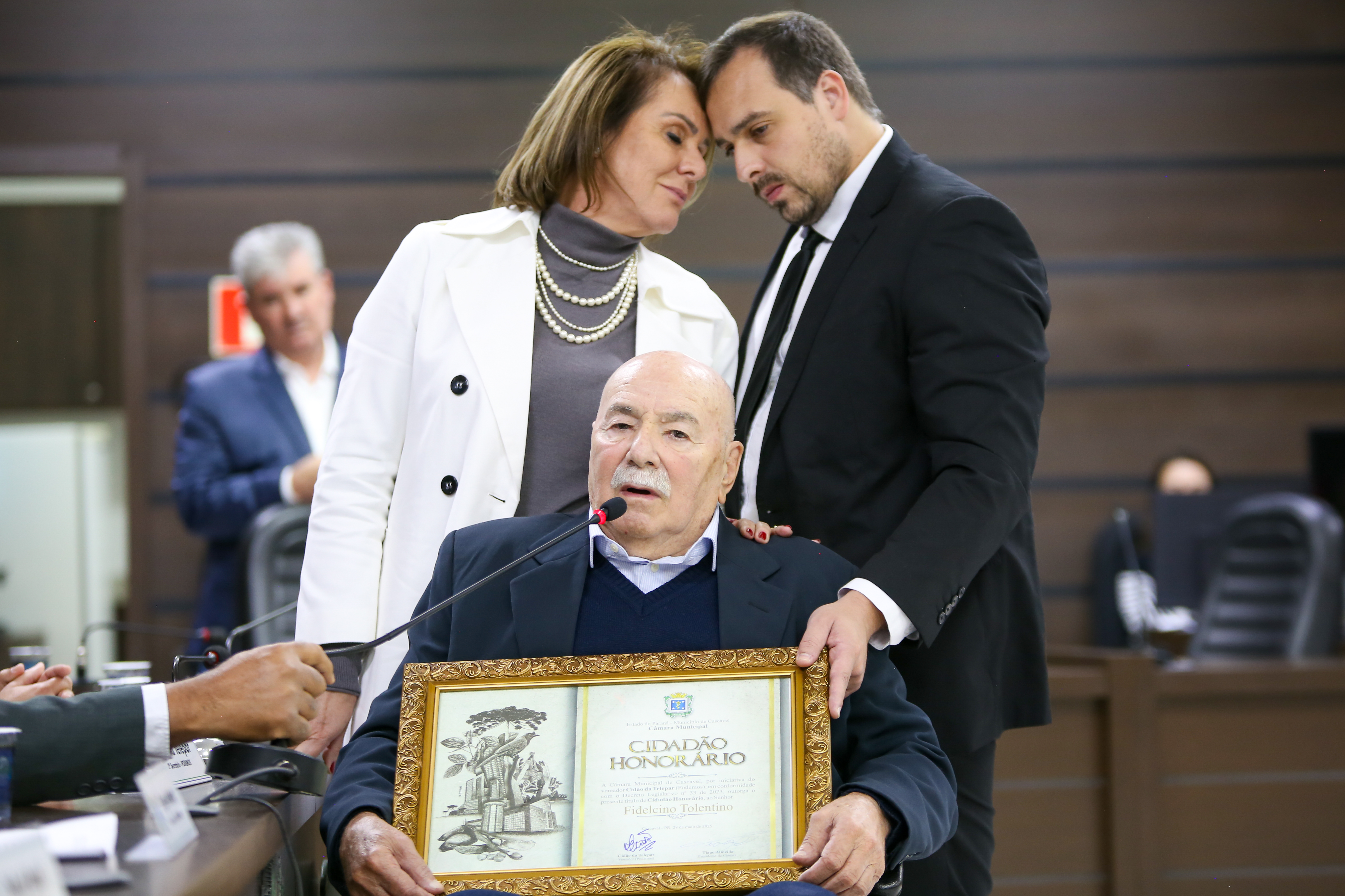 Emocionados, a esposa Fabiana e o filho Fernando acompanham Fidelcino Tolentino ao receber a homenagem