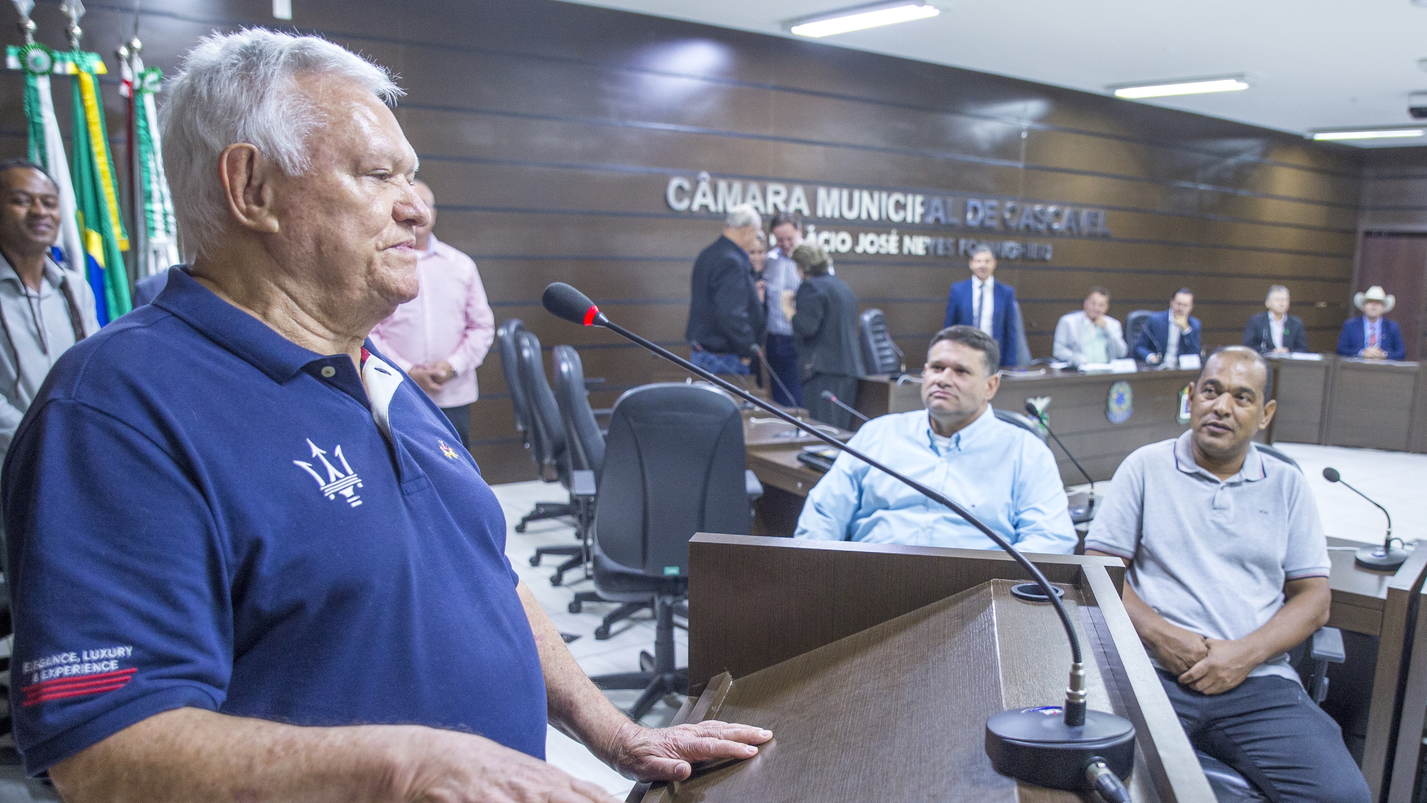 Alexandre Mantovani Neto é observado pelo filho Luiz Fernando e pelo Policial Madril ao agradecer a homenagem