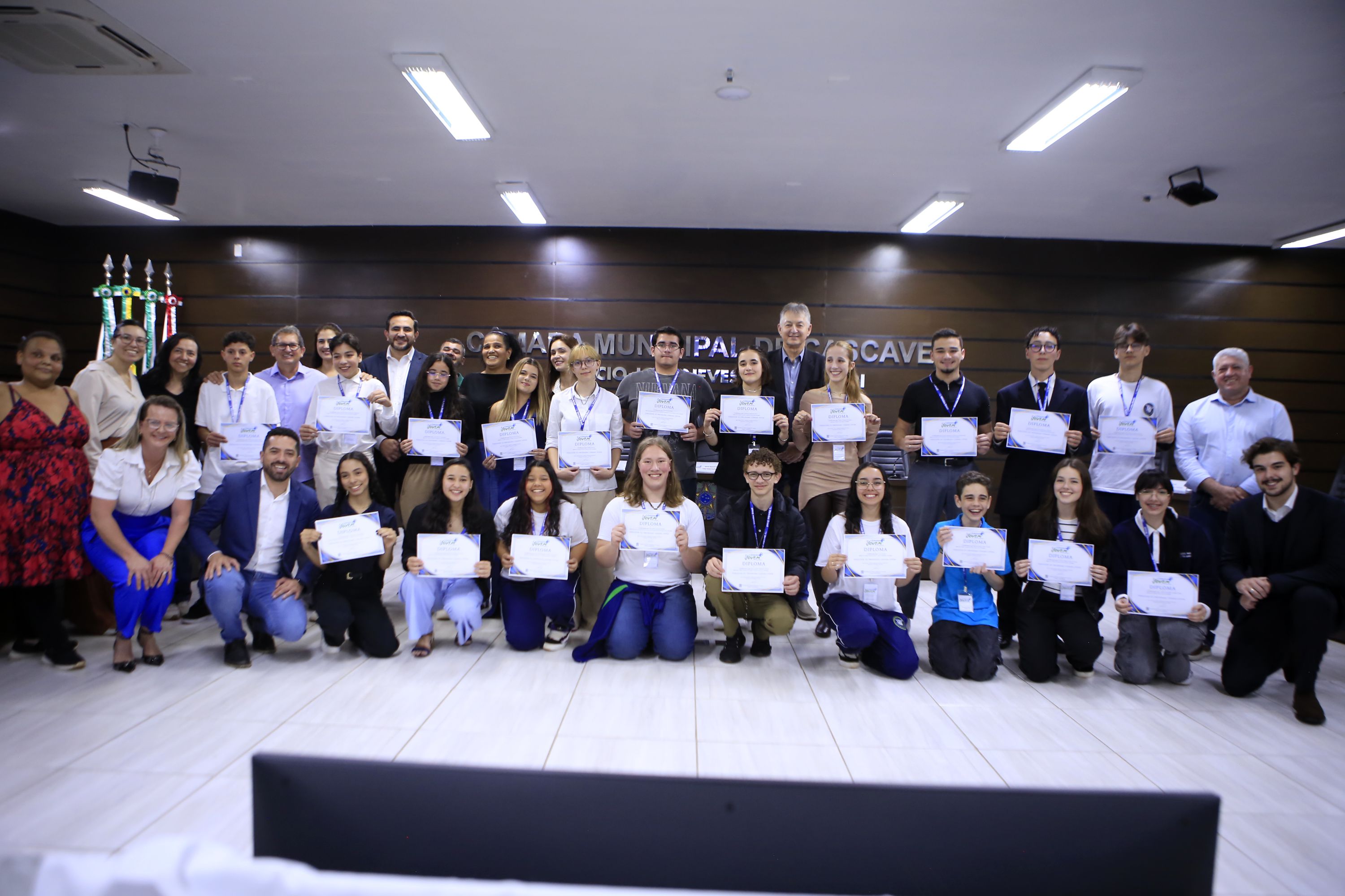 Vereadores jovens posam com integrantes da mesa de honra após a posse